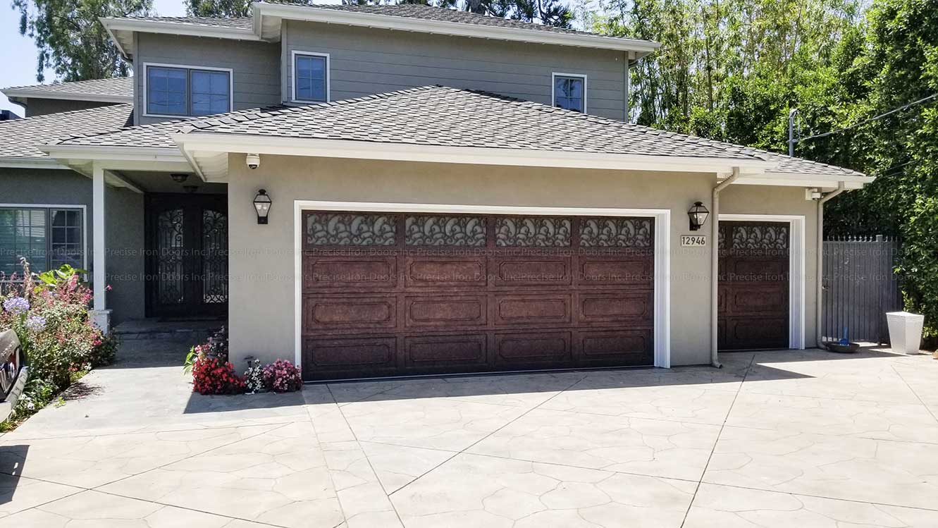Gray home with iron doors and iron garage