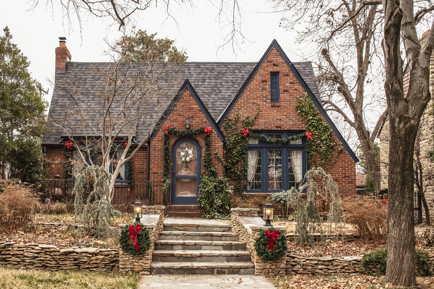 Cute brick cottage with red bows and greenery