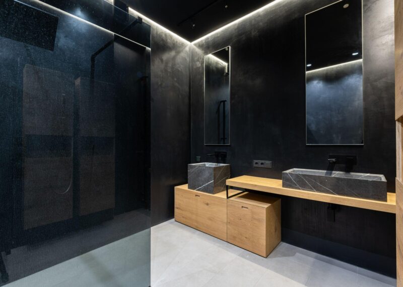 Creative minimalist bathroom with black walls and sinks