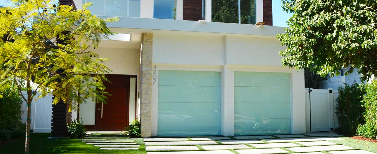 Modern house with frameless garage doors from Precise Iron Doors